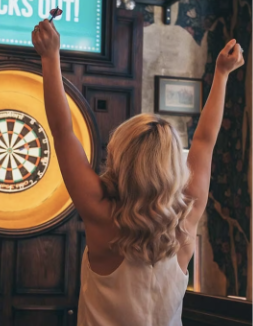 Person celebrating next to dart board